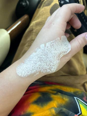 Peeling translucent skin or mask on a person's hand, possibly demonstrating skincare or beauty treatment product application