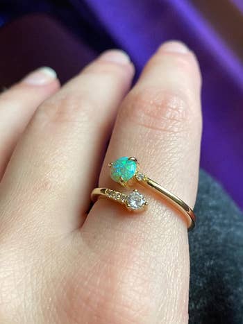 reviewer wearing yellow gold and blue green stone version
