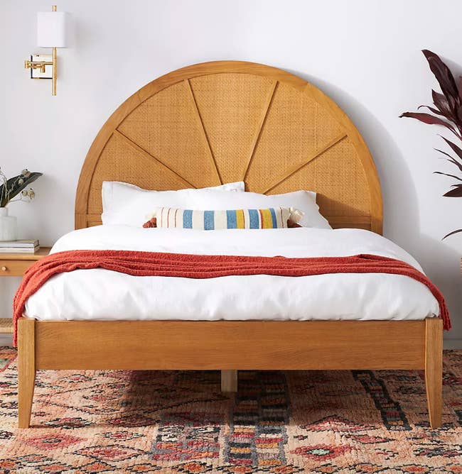 wooden bed frame with rounded cane headboard