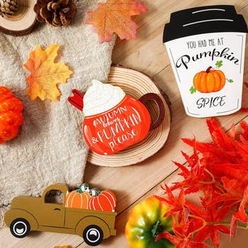 three wooden signs shaped like coffee drinks, and a pickup truck with pumpkins in the back