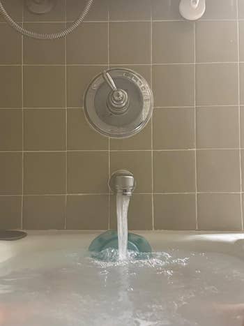 Bathtub with h2o  moving  from the faucet, filling up