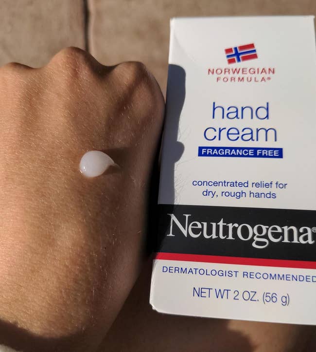 reviewer with dab of lotion on the back of their hand