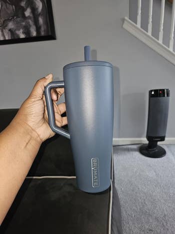 reviewer holding blue tumbler
