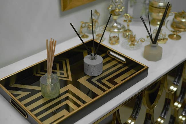 the black and gold tray holding oil diffusers