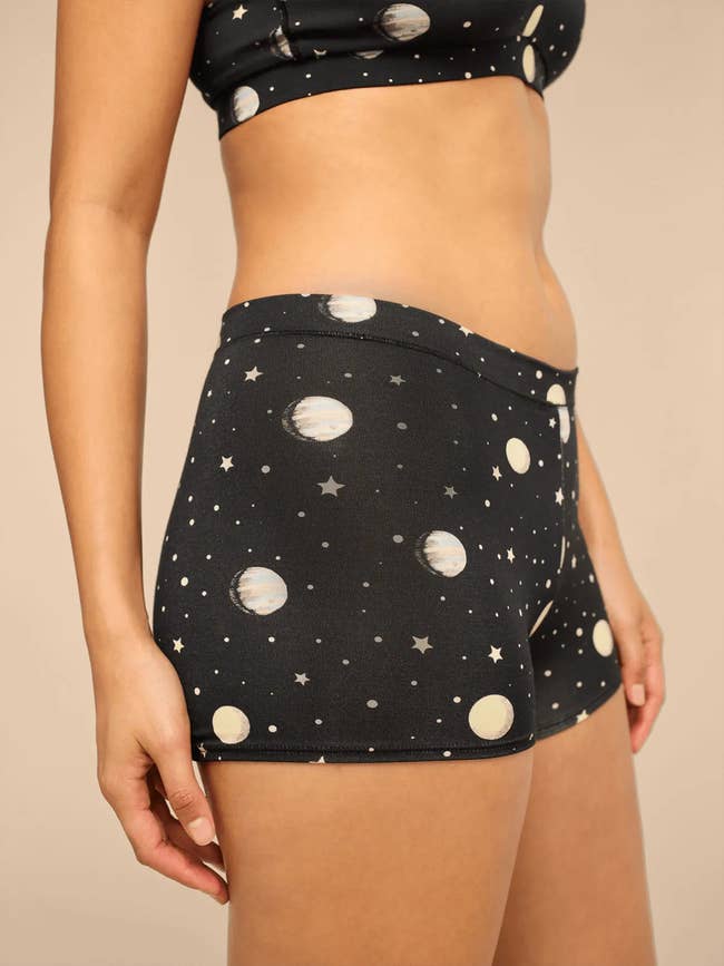 Person wearing satellite and prima people activewear shorts connected a neutral background