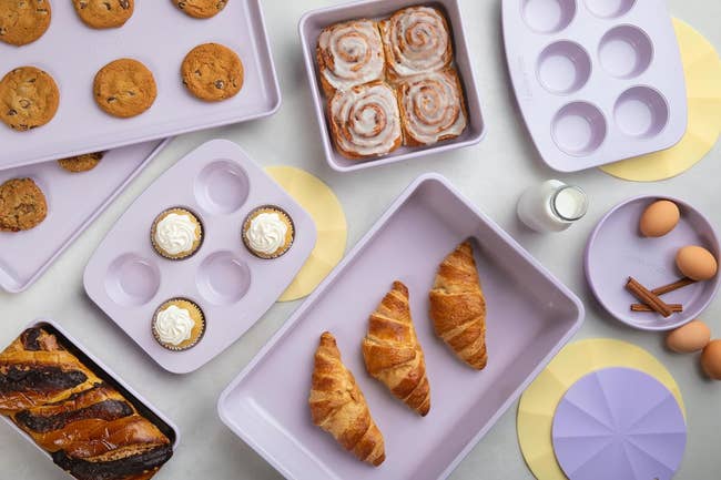 Assorted baked goods laid out next to baking trays and ingredients, likely for sale or recipe inspiration