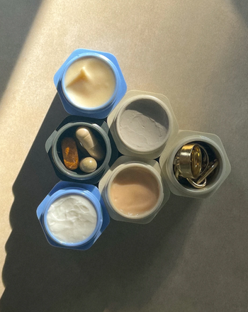 blue and white mini capsules filled with skin creams, vitamins, and jewelry