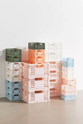 Stacked colorful plastic storage crates against a neutral background