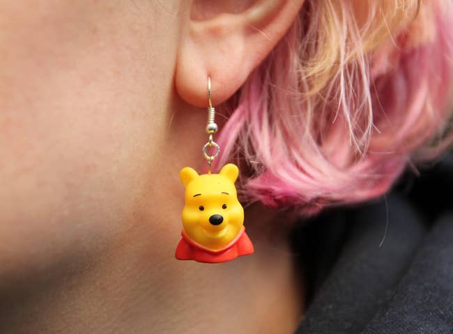 person wearing winnie the pooh earrings