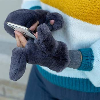 a model wearing the mittens in grey