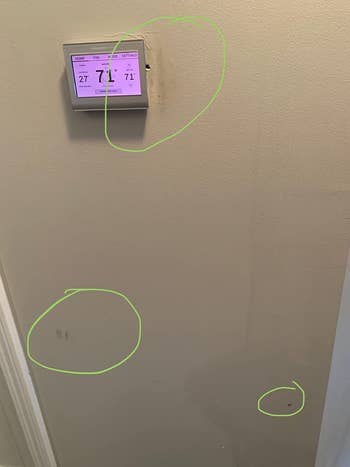 reviewer before image of a wall with circled dark marks on it