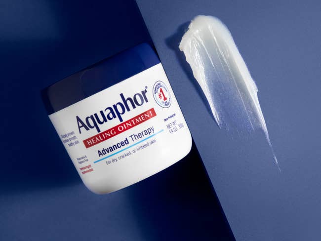 Jar of Aquaphor Healing Ointment beside a swatch of ointment