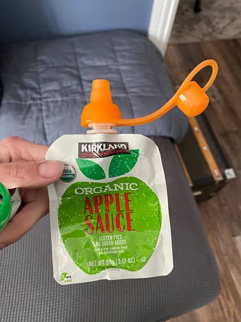 a reviewer showing the pouch lid on an apple sauce pouch