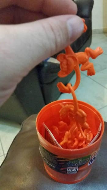 Reviewer holding orange plastic monkeys 