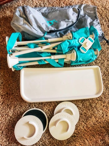 reviewer photo of the booster seat disassembled next to its carrying bag
