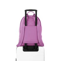 the purple backpack attached to a suitcase handle via its back strap