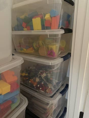 Stacked retention bins filled with assorted toys, including blocks and operation materials, neatly organized connected shelves