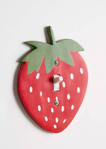 Strawberry-shaped light switch cover with green leaf detail, enhancing home decor