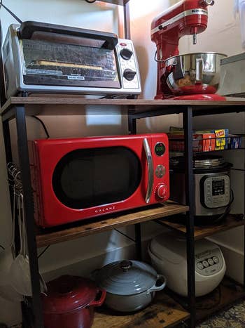 a reviewer photo of a microwave on a shelf in red