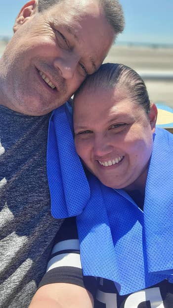 reviewer photo of two people with the cooling towel draped around their necks at the beach