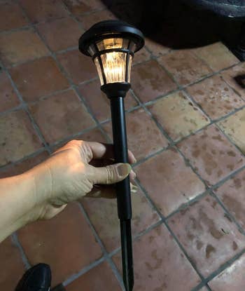 reviewer holding one of the lights to show its stake