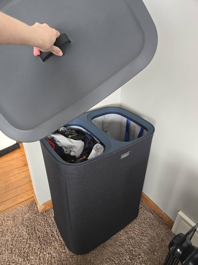 A 2-section laundry hamper with compartments for separating apparel is shown with its lid lifted