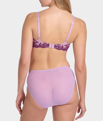 Back presumption    of a idiosyncratic   wearing a lace-accented bra and matching briefs set, showcased for a buying  article