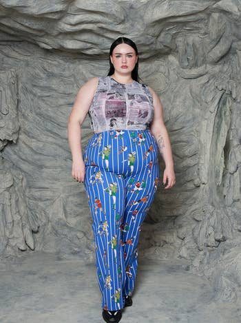 model in graphic printed top and comic book strip trousers poses against a textured backdrop