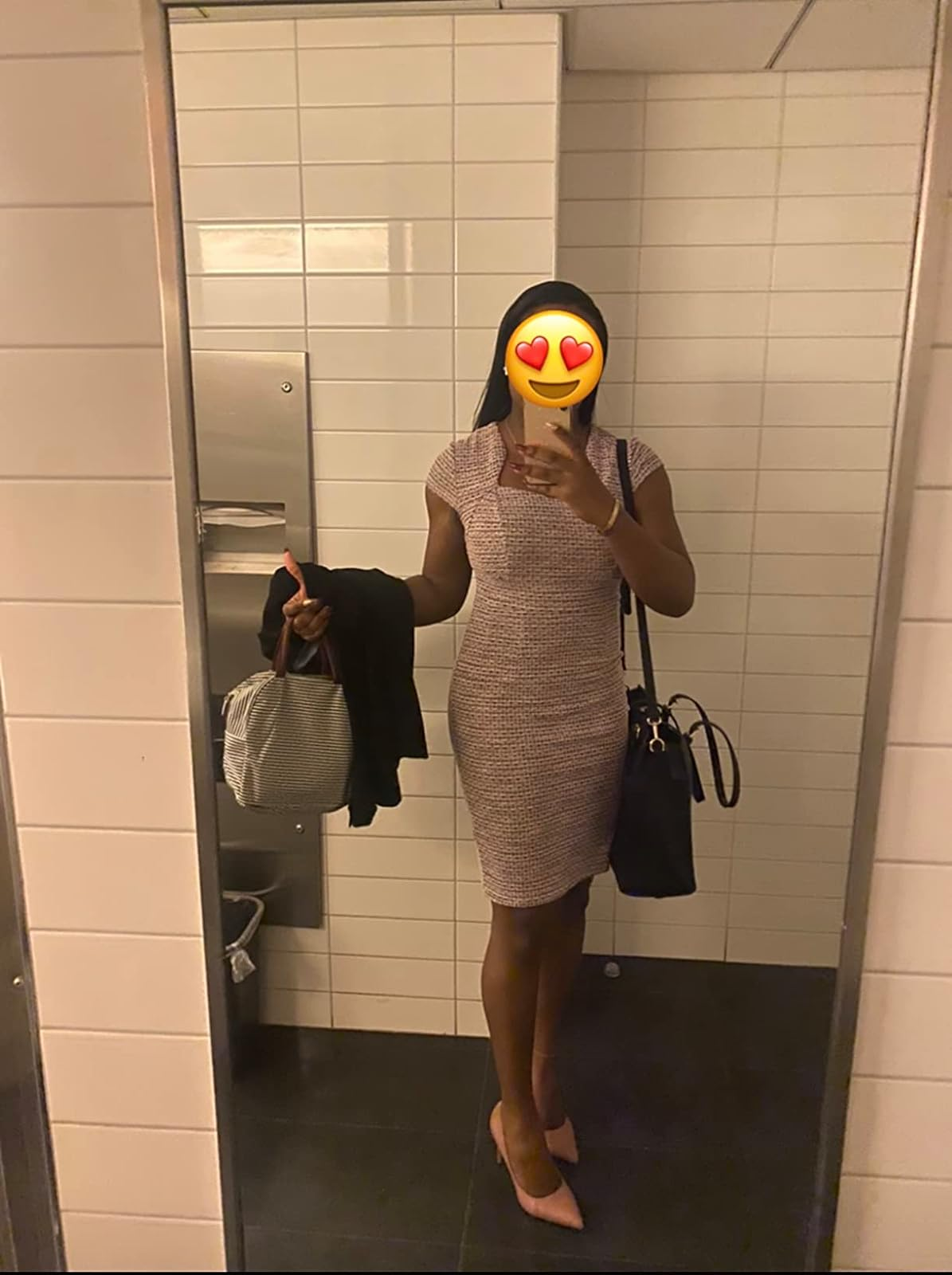 Person taking a mirror selfie, holding a jacket and bag, wearing a sleeveless tweed dress, suitable for a business casual look