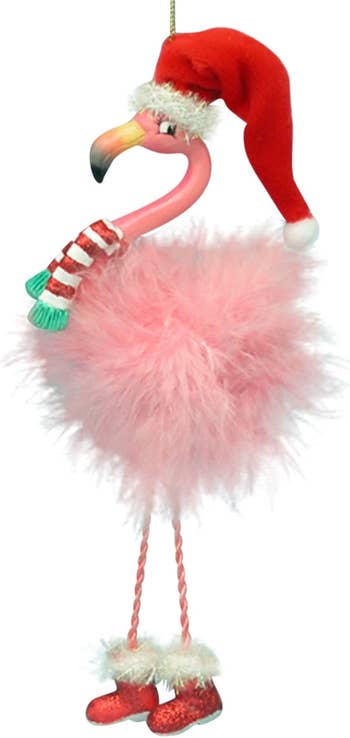 an ornament of a flamingo with a pink feathery body and a red santa hat on