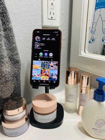 reviewer photo of iPhone in phone stand on bathroom counter