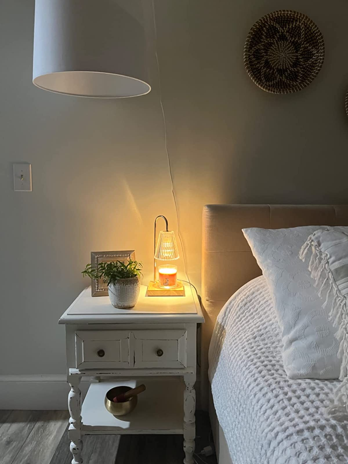 A reviewer shows the lamp on their bedside table