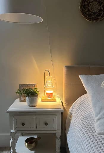 A reviewer shows the lamp on their bedside table