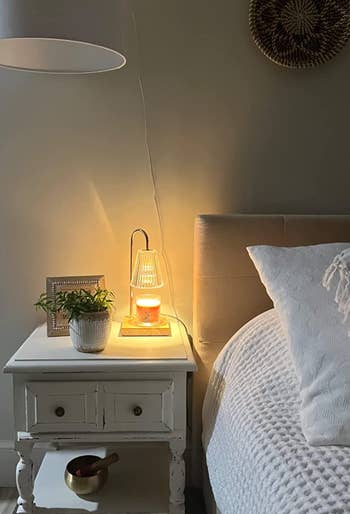 A reviewer shows the lamp on their bedside table