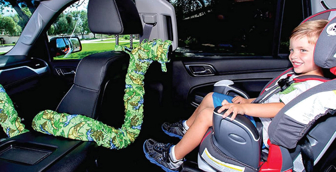 A young model is seated in a car seat with a tube pointing at them