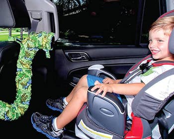 A young model is seated in a car seat with a tube pointing at them