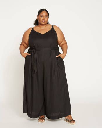 model in black sleeveless jumpsuit with tie waist