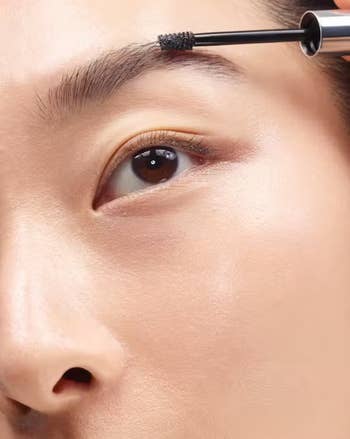close up of model applying the product to eyebrow