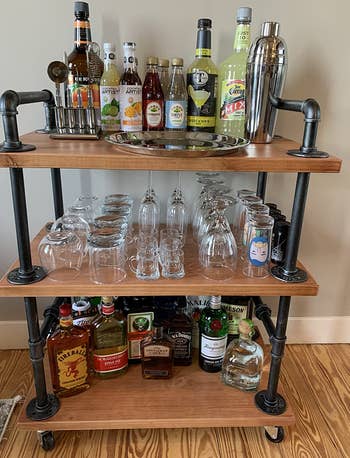 Reviewer image of the pipe bar cart with glasses and bottles