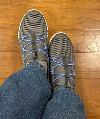 Reviewer wearing gray sneakers with blue jeans