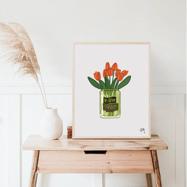 Framed people     of reddish  tulips successful  an Mt. Olive pickle jar connected  a woody  table. Decor includes a achromatic  vase with pampas grass, placed successful  a minimal room