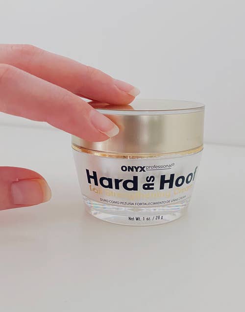 reviewer's hand holding a jar of Onyx Professional Hard as Hoof nail strengthening cream