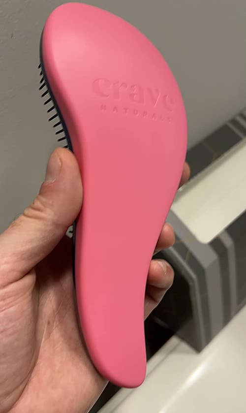 reviewer's photo of the ergonomic shaped brush in pink