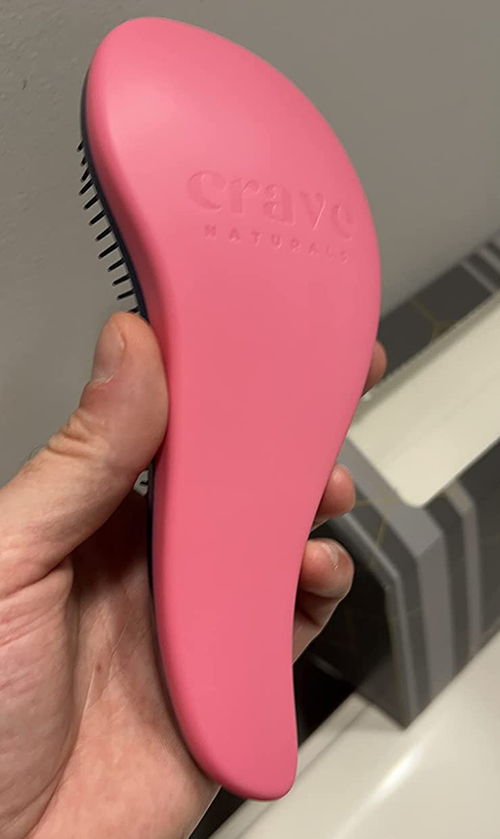 reviewer's photo of the ergonomic shaped brush in pink