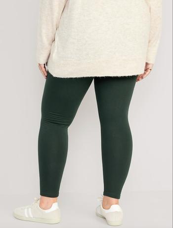 Model showing the back of the leggings in dark green 