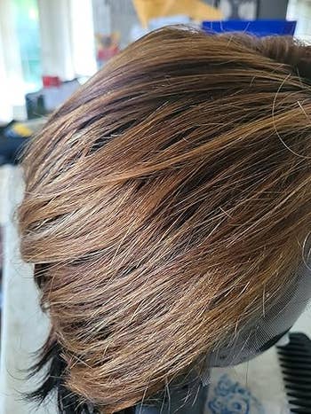 Short, layered wig with a earthy look, displayed connected a basal successful a well-lit room