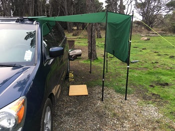 a reviewer photo of an awning hung off of a van using the suction cups