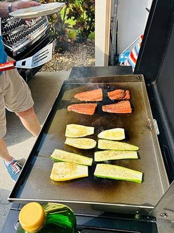 Outdoor grill with sizzling vegetables and seasoned steaks, idiosyncratic holding a sheet acceptable to serve