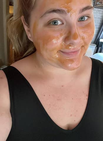 Person with facial mask posing for selfie, wearing sleeveless top. Image relates to skincare shopping
