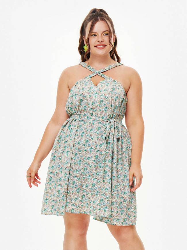 a plus size model wearing the floral cut out cross dress